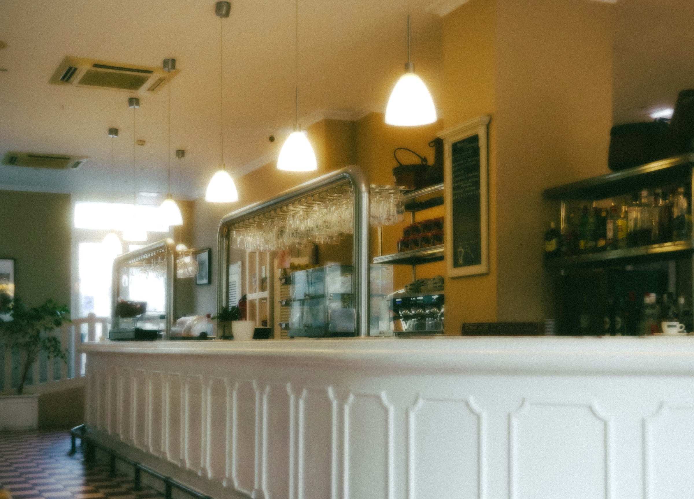 Prázdný bílý bar kavárny pod rozsvícenými lampami