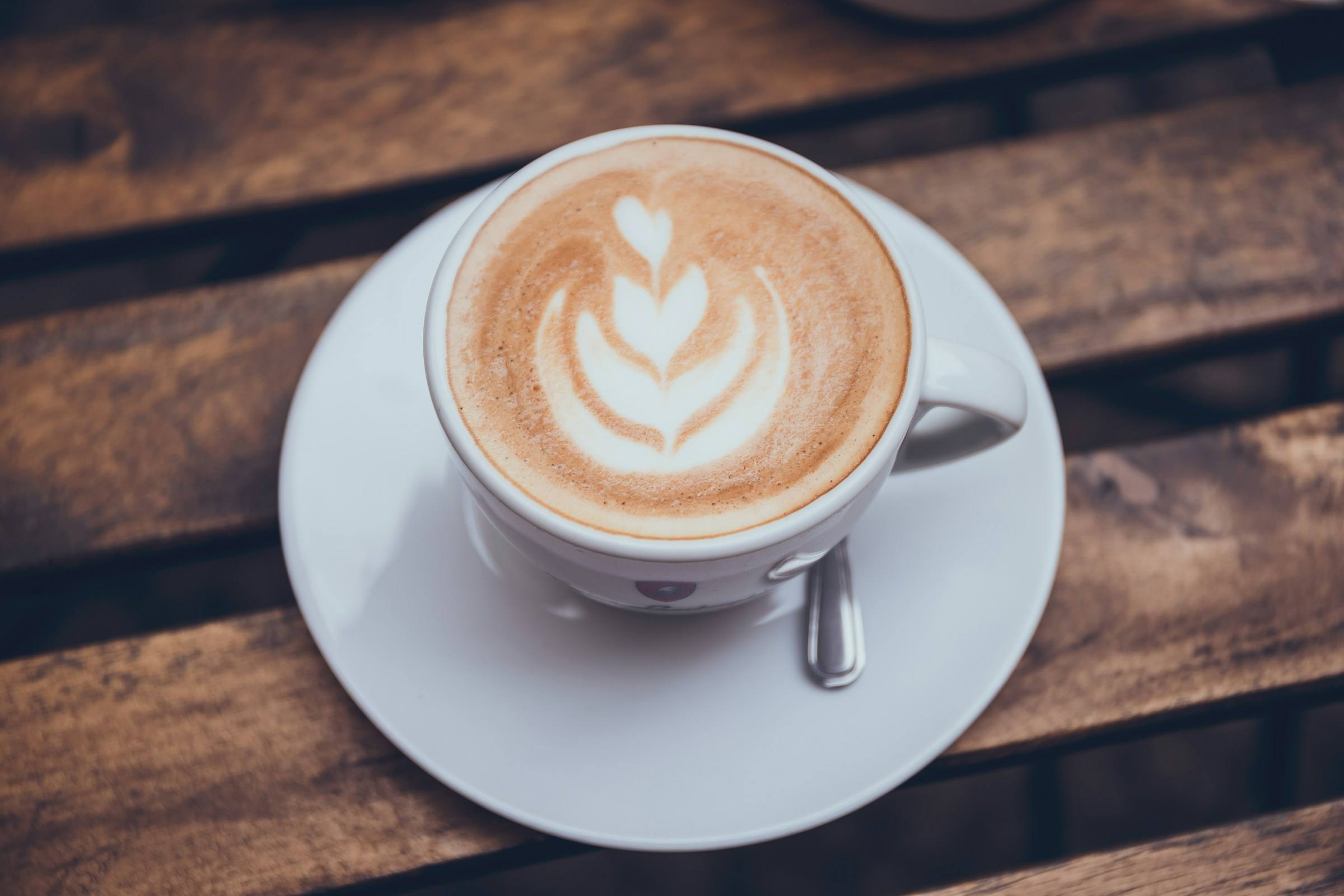 Kapučíno s latte art na dřevěném stole